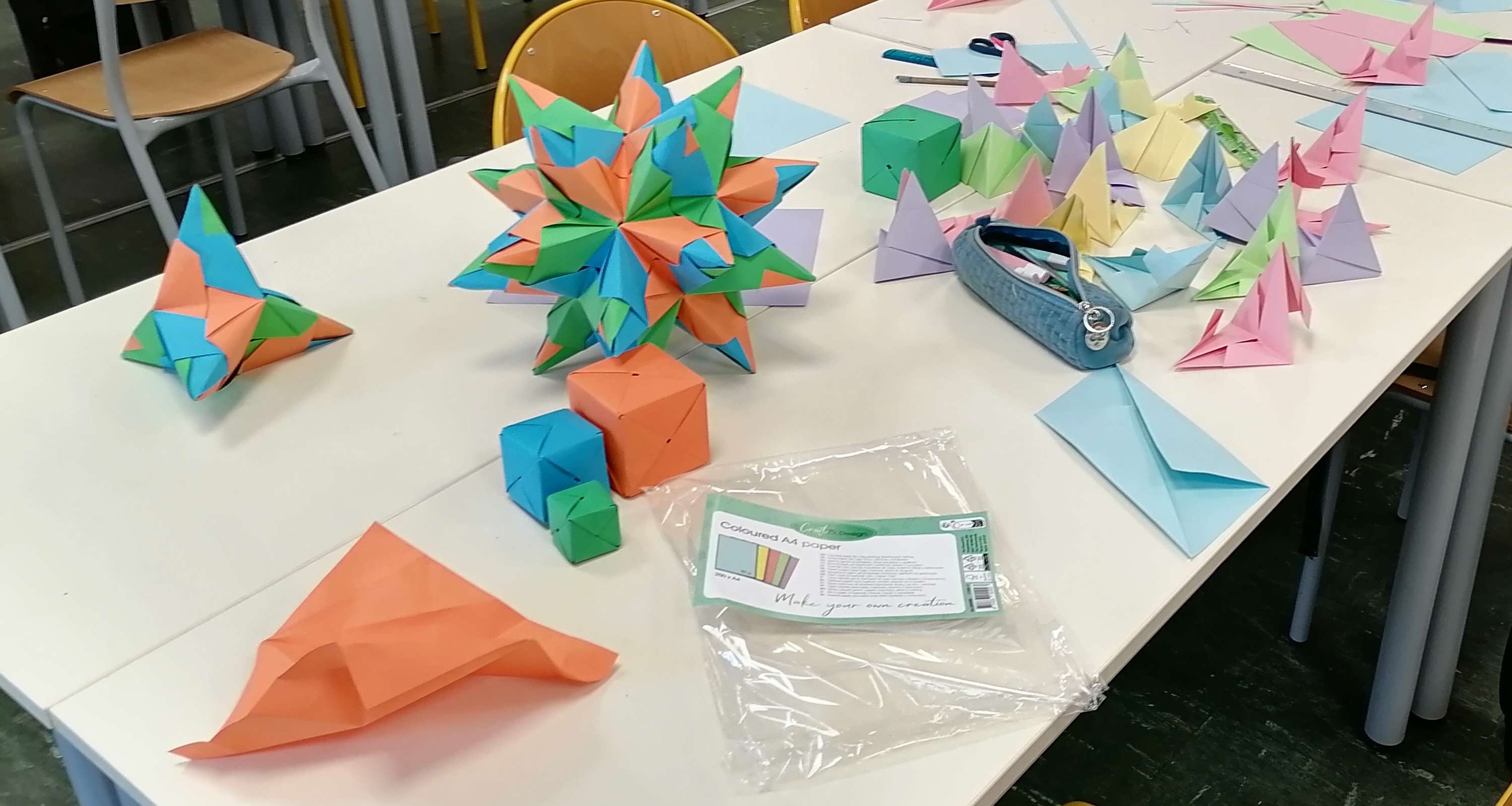 Photographie d'une table recouverte d'origamis pour illustrer un des ateliers lors de la semaine des mathématiques.